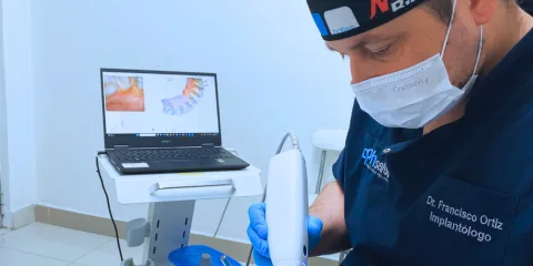 Odontólogo de CPH Salud escaneando con scanner intraoral junto al modelo 3D en pantalla